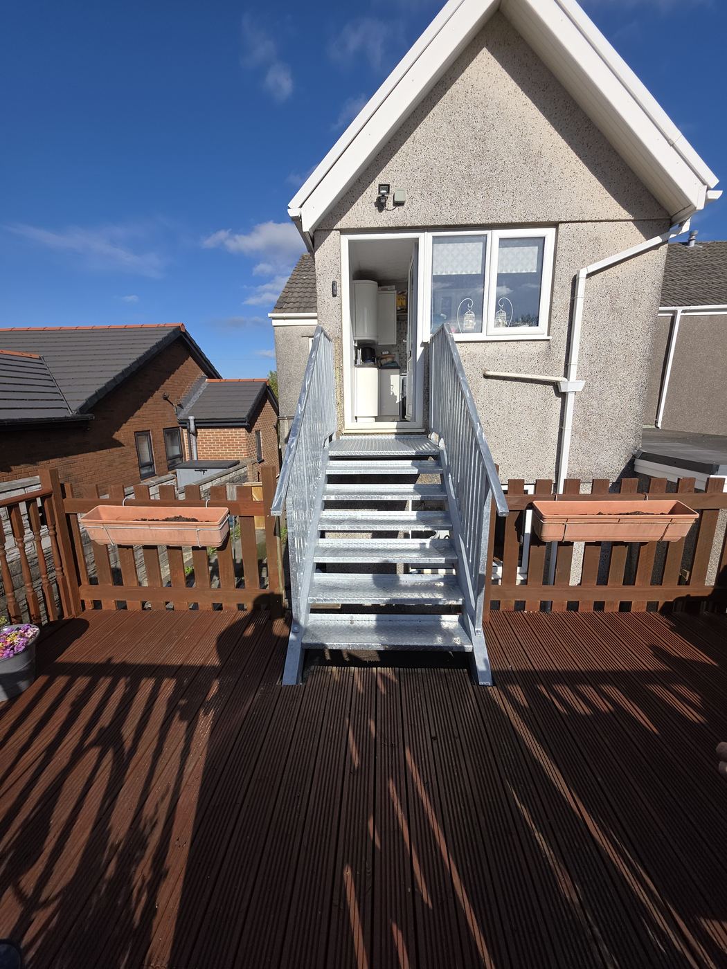 Galvanised fire escape staircase to raised deck